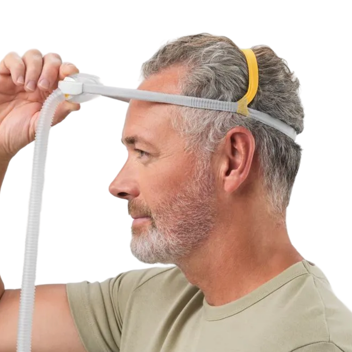 Image showing a man taking of his mask by holding the mask cushion and lifting it up.
