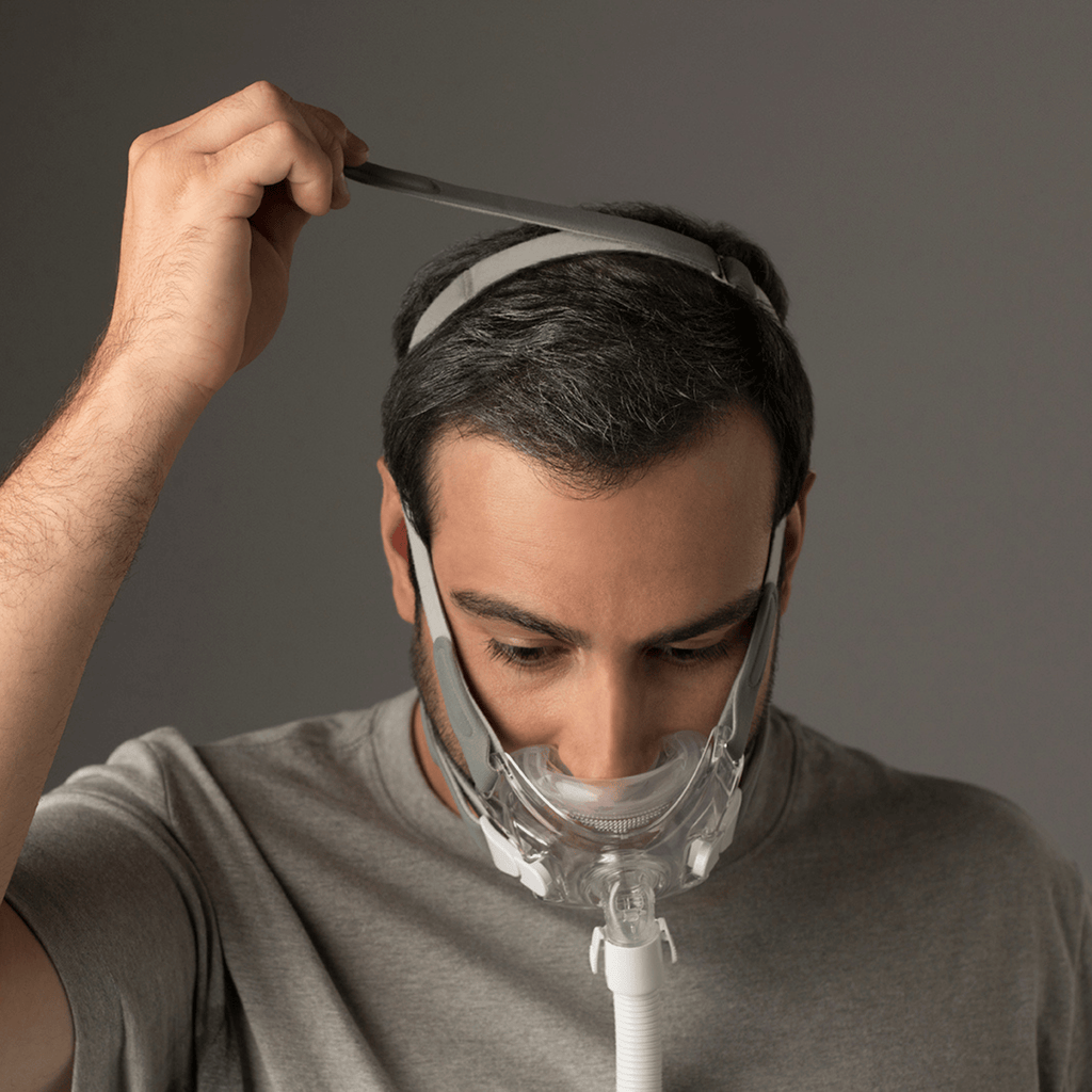 man wearing amara view mask adjusts the crown strap at the top of the head