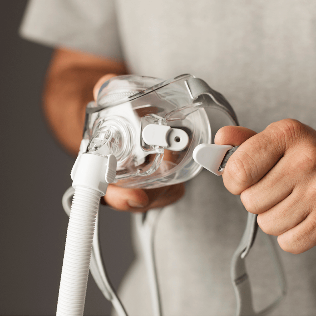 hands hold the amara view and show closeup of magnetic headgear clip