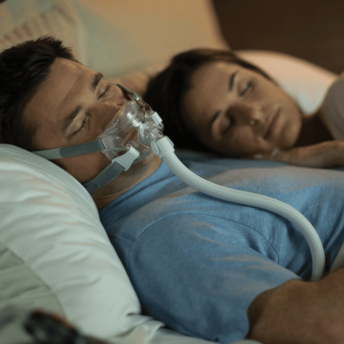 man sleeping in amara view mask with his wife nearby