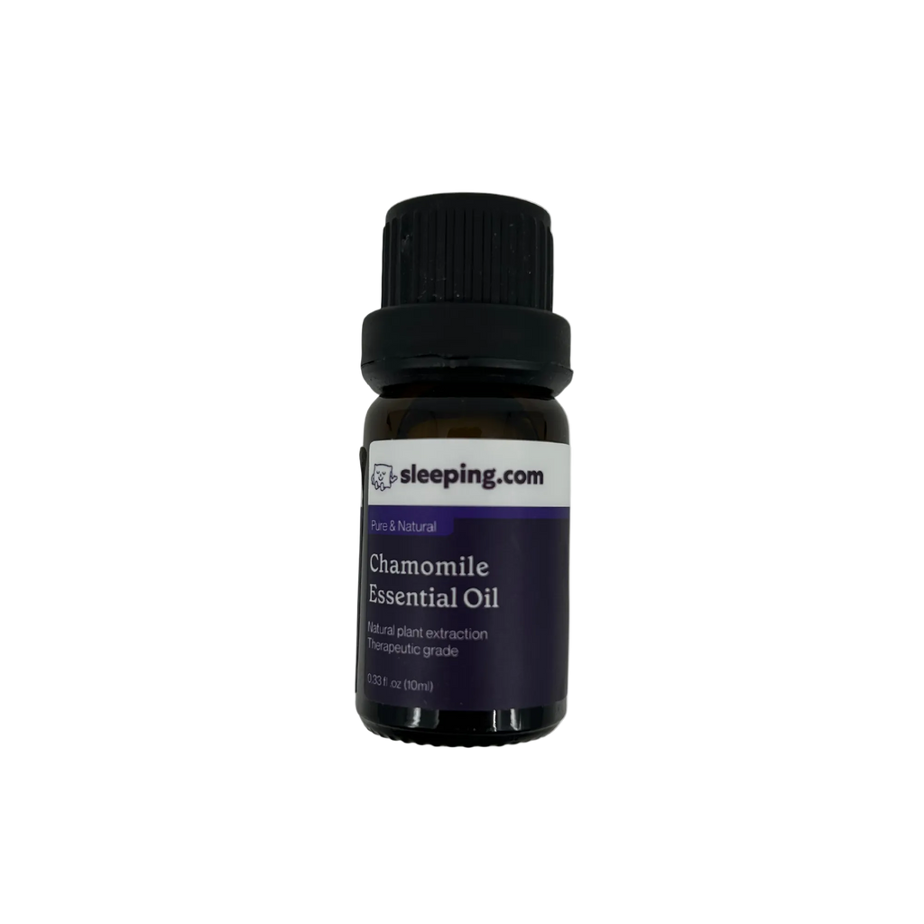 A small amber glass bottle of sleeping.com Chamomile Essential Oil with a black ribbed cap and a dark purple label, centered on a plain white background.