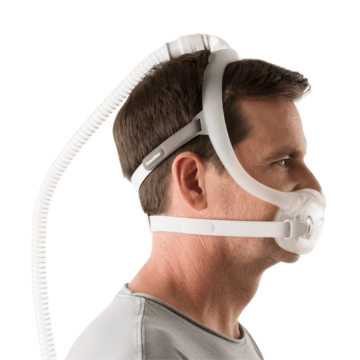 man wearing the dreamwear full face mask seen from the side profile with tubing connected overhead